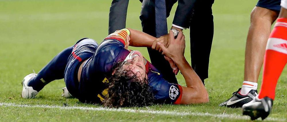 Carles Puyol windet sich vor Schmerzen nach seinem Sturz beim Champions-League-Match gegen Benfica Lissabon.
