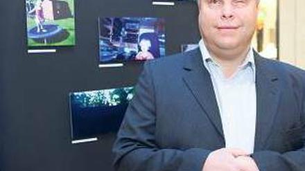 Sein Familienalbum. Ralf Heinemann-Hohn hatte seine Tochter noch nie fotografiert, er kann die Fotos nicht sehen. Die Kleine juchzte, als sie sich in der Ausstellung sah. Foto: Georg Moritz