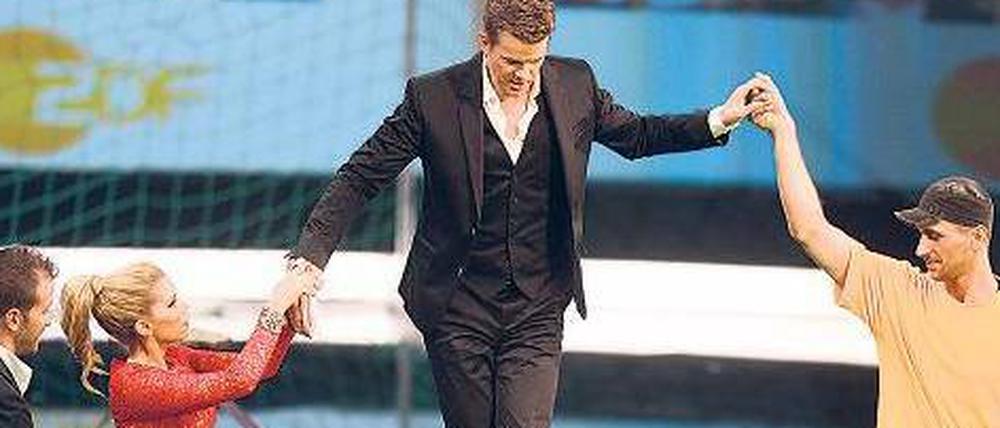Einen Balanceakt musste Markus Lanz (M.) am Samstagabend bei seiner ersten Moderation von „Wetten, dass..?“ im ZDF meistern. Fußballer Rafael van der Vaart (l.), dessen Frau Sylvie und Wettkandidat Cihan Calis boten Hilfe an. 