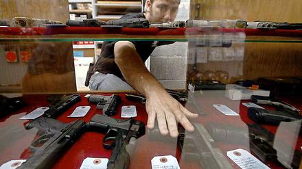 Für viele Amerikaner sind Waffen Teil ihrer Identität. Im Bild: Der Verkäufer eines Waffengeschäftes in Wichita, Kansas, greift in einer Auslage nach einer Pistole.