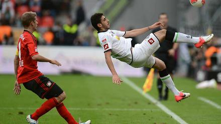Tolga Cigerci hält den Ball vor den Augen von Natioanlspieler Lars Bender artistisch im Spiel.