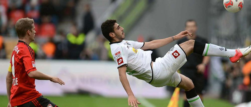Tolga Cigerci hält den Ball vor den Augen von Natioanlspieler Lars Bender artistisch im Spiel.