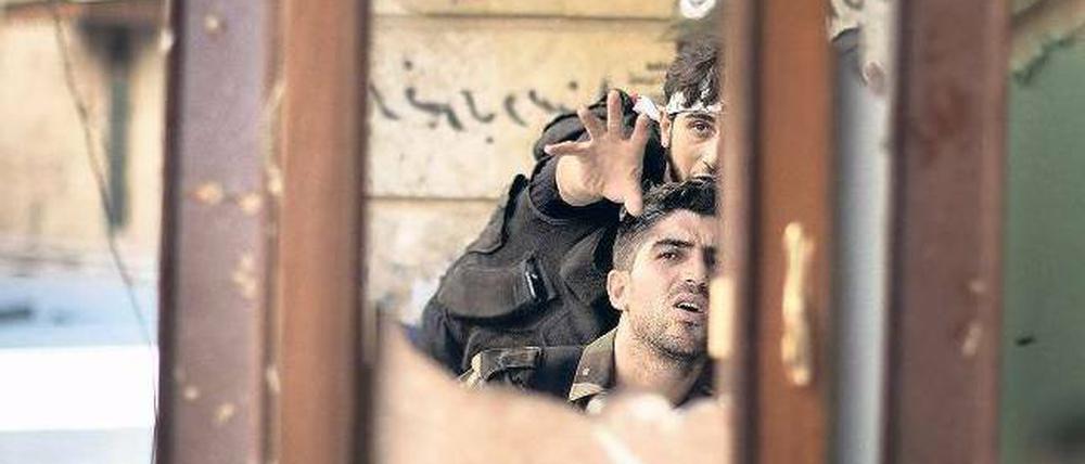 Kämpfer in Aleppo beobachten mithilfe eines Spiegels einen Posten der regulären Armee. Auf eine internationale Militärintervention setzen sie nicht mehr. Foto: Marco Longari/AFP