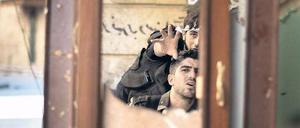 Kämpfer in Aleppo beobachten mithilfe eines Spiegels einen Posten der regulären Armee. Auf eine internationale Militärintervention setzen sie nicht mehr. Foto: Marco Longari/AFP