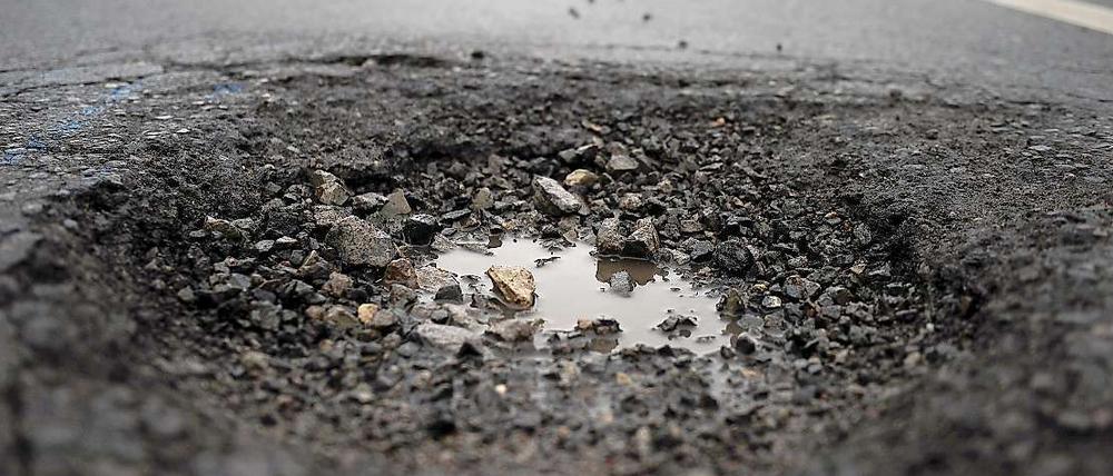 Schlaglöcher, wie hier auf der Straße des 17. Juni, marode Gehsteige und unbefahrbare Radwege gehören in Berlin zum Stadtbild.