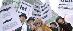 Verkleidet als Millionäre, gehen diese Demonstranten gegen die geplante Vermögenssteuer auf die Straße