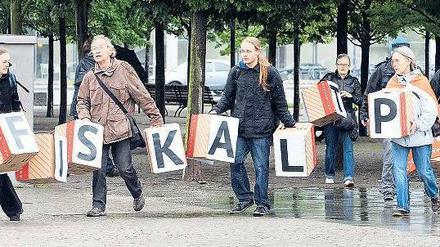 Würfelspiel. Am Sonntag war der Fiskalpakt Gesprächsthema im Kanzleramt – wie schon vor Tagen. Vor der Tür demonstrierten Attac-Aktivisten. Foto: Wolfgang Kumm/dpa