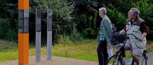 Orangefarbene Stelen erinnern am Mauerweg in Teltow an die Menschen, die bei Fluchtversuchen entlang der Mauer erschossen wurden.