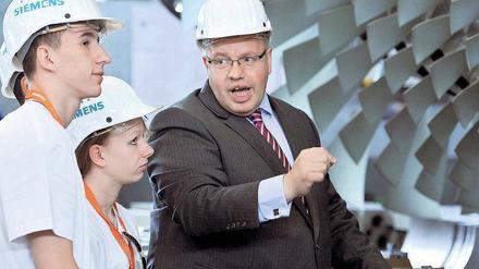 Volle Kraft vor der Gasturbine. Umweltminister Peter Altmaier ist zwar studierter Jurist, kann sich aber durchaus für Technik begeistern – vor allem, wenn sie Energieeffizienz verspricht. Berliner Jugendliche warfen mit ihm einen Blick auf die Fertigung bei Siemens. Foto: dapd