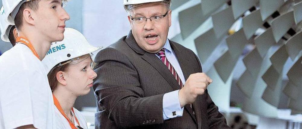 Volle Kraft vor der Gasturbine. Umweltminister Peter Altmaier ist zwar studierter Jurist, kann sich aber durchaus für Technik begeistern – vor allem, wenn sie Energieeffizienz verspricht. Berliner Jugendliche warfen mit ihm einen Blick auf die Fertigung bei Siemens. Foto: dapd