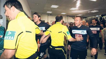 Blankes Entsetzen. Herthas Spieler bestürmen Schiedsrichter Wolfgang Stark, doch der lässt die Partie nach minutenlanger Unterbrechung fortsetzen. Foto: Streubel