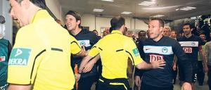 Blankes Entsetzen. Herthas Spieler bestürmen Schiedsrichter Wolfgang Stark, doch der lässt die Partie nach minutenlanger Unterbrechung fortsetzen. Foto: Streubel