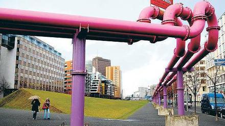 Lange Leitung. Dicke Rohre leiten das Grundwasser von der Baustelle am Leipziger Platz bis in den Landwehrkanal. Würde nicht ständig gepumpt, stünde die mehr als zehn Meter tiefe Baugrube sofort unter Wasser. Wie sehr die Nässe nachdrückt, zeigt sich auch am Potsdamer Platz (links im Bild), in dessen Tiefgarage Pfützen stehen.