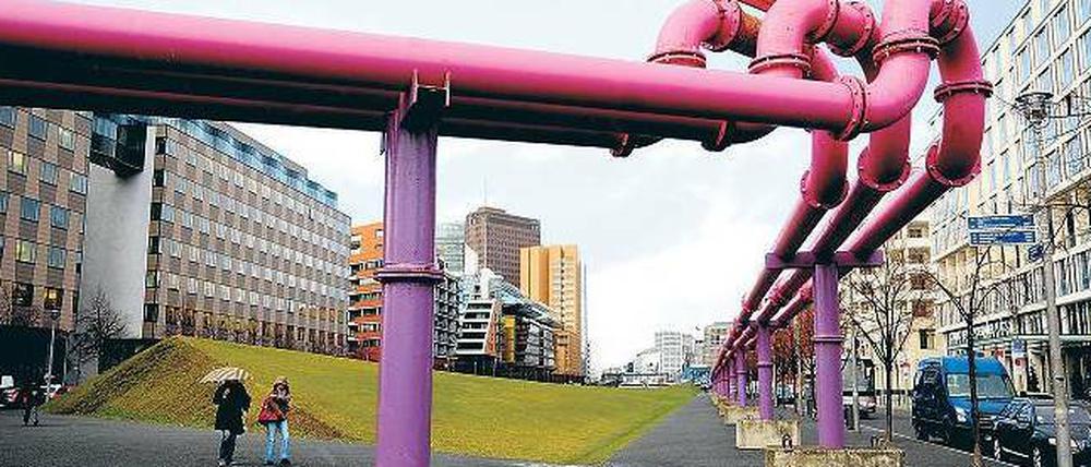 Lange Leitung. Dicke Rohre leiten das Grundwasser von der Baustelle am Leipziger Platz bis in den Landwehrkanal. Würde nicht ständig gepumpt, stünde die mehr als zehn Meter tiefe Baugrube sofort unter Wasser. Wie sehr die Nässe nachdrückt, zeigt sich auch am Potsdamer Platz (links im Bild), in dessen Tiefgarage Pfützen stehen.
