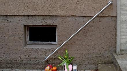 Anwohner haben Blumen und Kerzen vor dem Haus in Erkner abgelegt, wo eine Vierjährige getötet wurde.