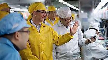 Ganz in Gelb: Apple-Chef Tim Cook beim Besuch von Foxconn, wo das Unternehmen einen Teil seiner Geräte produzieren lässt.