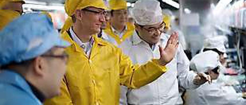 Ganz in Gelb: Apple-Chef Tim Cook beim Besuch von Foxconn, wo das Unternehmen einen Teil seiner Geräte produzieren lässt.