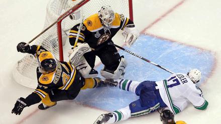 Nach dem Check: Dennis Seidenberg (Boston) dreht ab, Ryan Kesler (Vancouver) bleibt liegen.