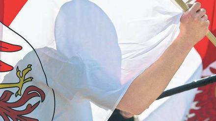 Flagge zeigen. Der Teilnehmer einer europafeindlichen Demonstration von Neonazis am Wochenende in Frankfurt/Oder trägt eine Fahne mit dem Wappen des Landes Brandenburg. An der Veranstaltung einer rechten Kameradschaft nahmen auch mehrere NPD-Funktionäre teil. Auch die mögliche Verbindung der NPD zu terroristischen Gruppen gerät immer mehr ins Visier der Ermittler - es gibt neue Anhaltspunkte, dass die Thüringer Terrorzelle einem heutigen NPD-Abgeordneten Geld spendete. Foto: Patrick Pleul/dpa