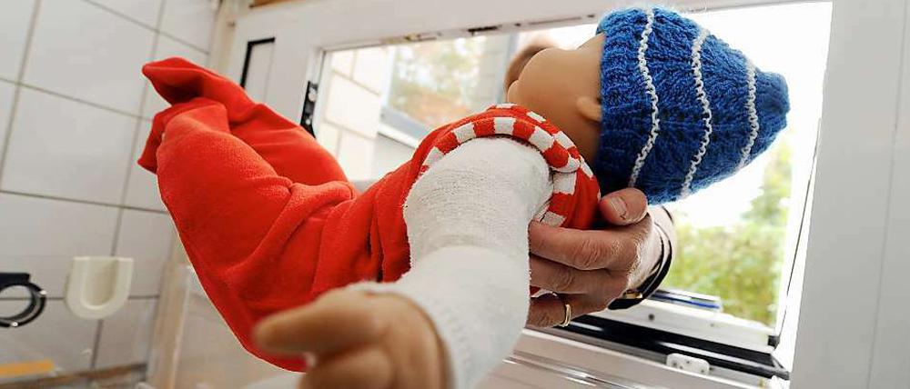 Mit einer Babypuppe wird das Ablegen eines Kindes in einer Babyklappe simuliert.