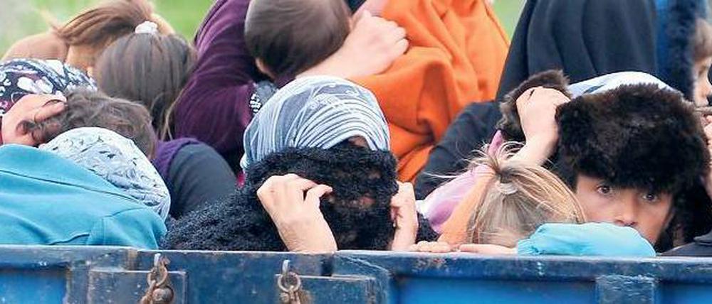 Auf einem Pritschenwagen erreichen syrische Flüchtlinge am Donnerstag Reyhanli in der Südtürkei. Den Minengürtel vor der Grenze haben sie verängstigt, aber heil passiert.