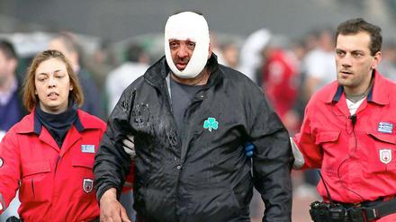 Sanitäter führen einen Verletzten nach dem eskalierten Spiel in Athen aus dem Stadion.