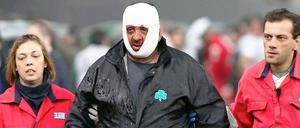 Sanitäter führen einen Verletzten nach dem eskalierten Spiel in Athen aus dem Stadion.