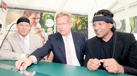 Am grünen Tisch des Sponsors. Ex-Bundespräsident Christian Wulff vergnügte sich 2011 beim Sommerfest im Schloss Bellevue am Stand des Mobilfunkunternehmens E-Plus mit Schauspieler Ralf Möller (l.) und Moderator Cherno Jobatey. 