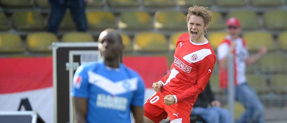 Fortunas Ken Ilsö jubelt über sein Tor zum 3:0. Karlsruhes Bakary Soumare ist geschlagen.