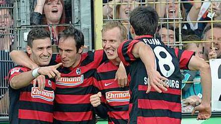 Die Freiburger Spieler feiern ihren Siegtorschützen Daniel Caligiuri (l.).