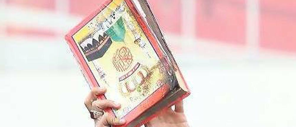 Hitziger Protest. Demonstranten im afghanischen Bagram mit einer Koranausgabe, die US-Soldaten ins Feuer geworfen haben sollen.