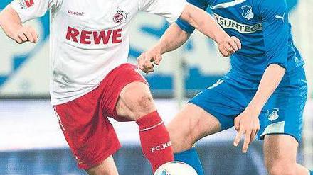 Du hältst mich auch nicht. Kölns Podolski (l.) gegen Hoffenheims Vestergaard. Foto: dpa