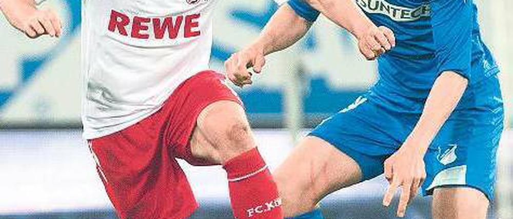 Du hältst mich auch nicht. Kölns Podolski (l.) gegen Hoffenheims Vestergaard. Foto: dpa