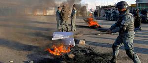 Ein Polizeibeamter in Kabul verbrennt eine Flagge der Taliban. 