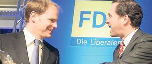 Fingerzeig. Der neue FDP-Landesvorsitzende Martin Lindner (r.) bedankte sich am Freitag nach seiner Wahl auf dem Landesparteitag bei seinem Vorgänger Christoph Meyer mit einer Flasche Rotwein. Die Berliner FDP trifft sich zu einem zweitägigen Parteitag.