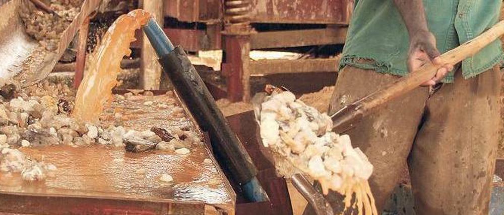 Roher Stoff. Ein Arbeiter sortiert herausgebrochenes Gestein einer Mine. Am Ende bleibt ein Konzentrat des Tantalerzes Coltan übrig, das von der Industrie heiß begehrt ist.