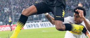 Luftnummer. Dortmunds Brasilianer Santana wird von Gladbachs Brasilianer Dante am großen Sprung gehindert. Foto: dapd
