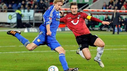 Leverkusens Stefan Kiesling und Hannovers Christian Schulz kämpfen um den Ball. Am Ende gewinnt keiner.