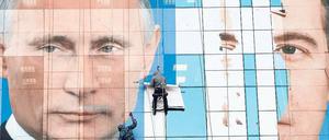 Putin bleibt – sein Rivale Medwedew (rechts) bleibt Episode: Plakatekleben im südrussischen Krasnodar. 