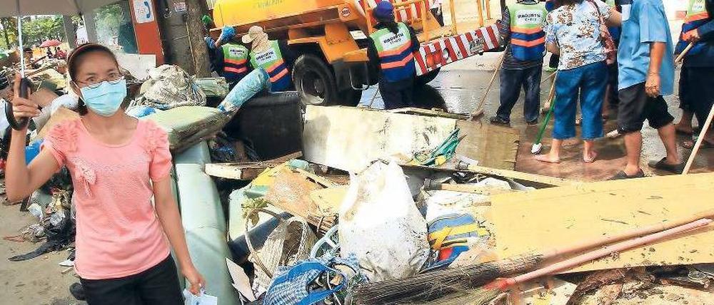 Die Katastrophe nach der Katastrophe. Das Wasser in Bangkok fließt langsam ab, zurück bleiben Schlamm und Müll. Für die Bewohner der betroffenen Stadtteile bleibt die Lage schwierig. Ihnen wird nun das ganze Ausmaß der Schäden bewusst. Foto: Narong Sangnak/dpa