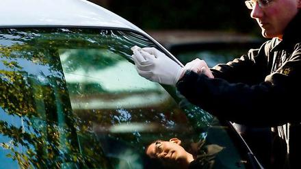 Ein Kriminaltechniker der Berliner Polizei am Tatort: Auf diesen Mietwagen soll nach Angaben des mutmaßlichen Opfers geschossen worden sein.