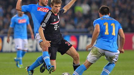 Harter Kampf um den Ball: Bayern Münchens Thomas Müller gegen Christian Maggio (rechts) und Walter Alejandro Guevara Gargano (links)