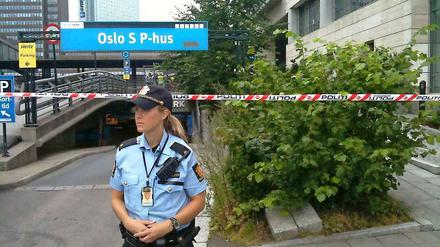 Eine Polizistin wacht vor einer Absperrung am Osloer Hauptbahnhof.