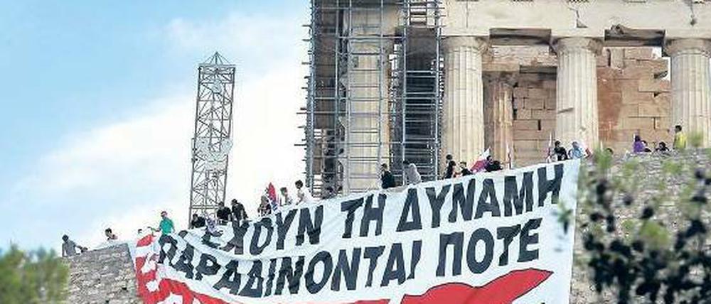 Protest. Der kommunistische Gewerkschaftsbund besetzte am Montag symbolisch die Akropolis und entrollte ein riesiges Plakat mit der Aufschrift „Die Völker haben die Macht und kapitulieren niemals“.