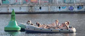 Schifffahrt – einst und heute. Auf dem Wasser lässt es sich bei diesem Wetter überall aushalten – selbst vor dem Wrack am Urbanhafen. Baden ist im Landwehrkanal aber nicht erlaubt.