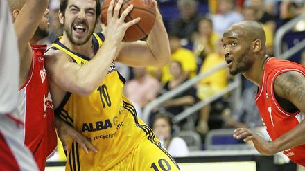 Berlins Taylor Rochestie (M) kämpft um den Ball mit Bambergs Reyshawn Terry (r) 