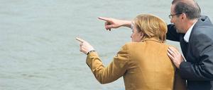 Blick auf die Wassermassen. Bundeskanzlerin Angela Merkel macht sich ein Bild von der Lage in Frankfurt (Oder). Gemeinsam mit Ministerpräsident Matthias Platzeck erklomm sie die Leiter an der Spundwand, die die Uferpromenade in der Stadt vor dem Hochwasser der Oder schützen soll. Foto: Patrick Pleul/dpa