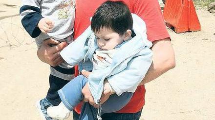 In Sicherheit. Immer mehr Syrer verlassen das Land. Manche, wie dieser Vater mit seinen Kindern, flüchten in den Libanon, andere in die Türkei. Foto: Omar Ibrahim/Reuters