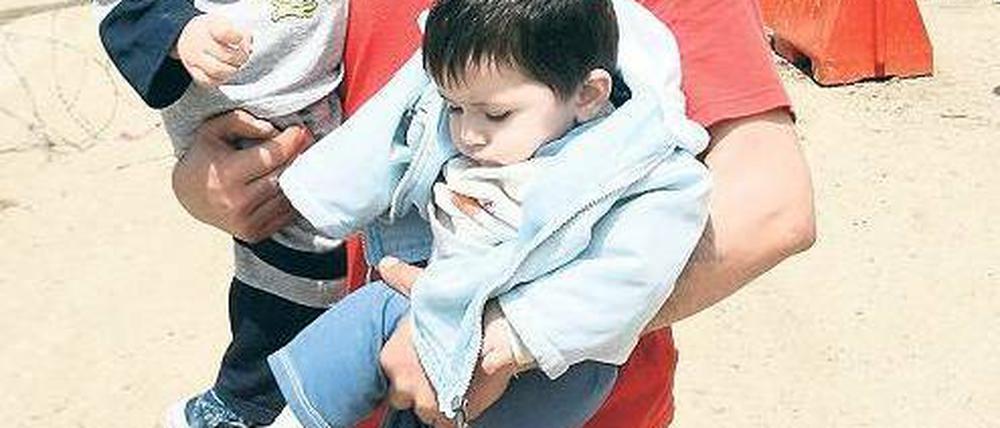 In Sicherheit. Immer mehr Syrer verlassen das Land. Manche, wie dieser Vater mit seinen Kindern, flüchten in den Libanon, andere in die Türkei. Foto: Omar Ibrahim/Reuters