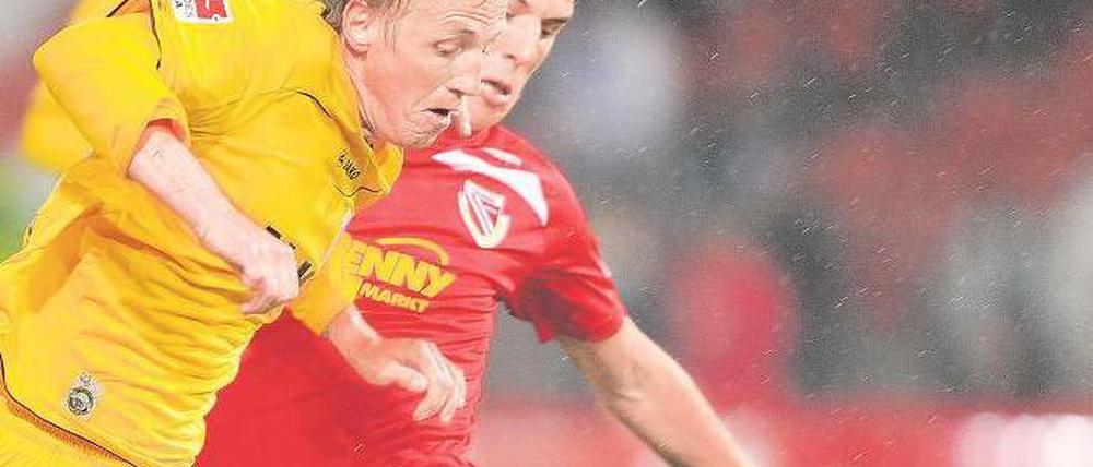 Augsburg tankt sich durch. Michael Thurk (l.) behauptet sich gegen Hünemeier. Foto: dpa